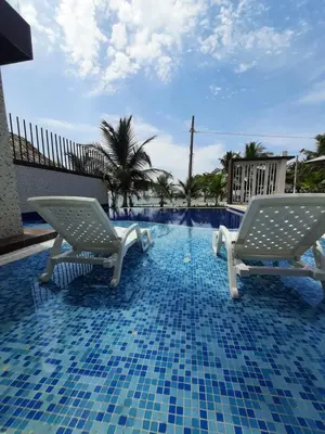 two chairs sitting next to a swimming pool at Loft 39 Casa de playa in Coveñas