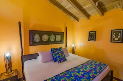 a bedroom with a bed with yellow walls at Casa Cordoba Román in Cartagena de Indias
