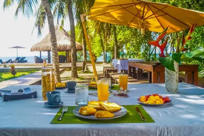 a table with plates of food and glasses of orange juice at Casa Cordoba Baru in Baru