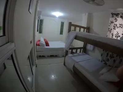 a small room with two beds and a mirror at La casita de max y tim apt 201 in Cartagena de Indias
