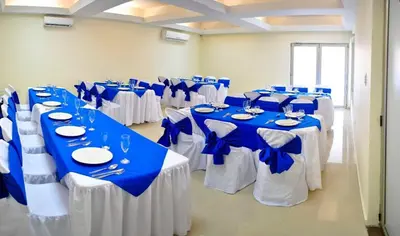 a room filled with tables with blue and white tablecloths at Hotel Rivera Del Mar in Barranquilla