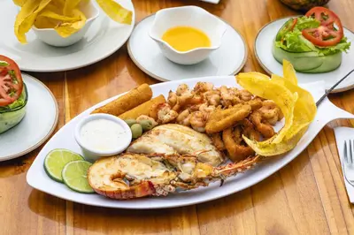 a plate of food with shrimp and fries on a table at Hotel Isla del Sol in Isla Grande