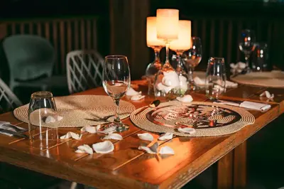 a wooden table with wine glasses and a plate on it at Hotel Isla del Sol in Isla Grande