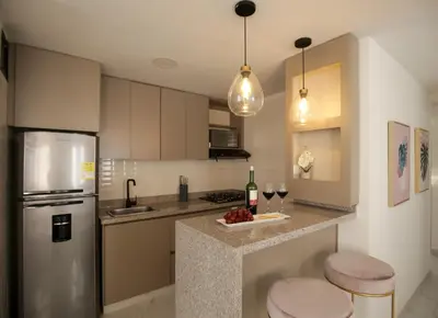 a kitchen with a refrigerator and two glasses of wine at Apartamento Edificio Portofino 701 in Cartagena de Indias