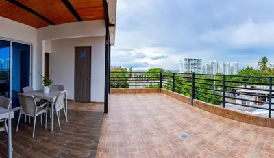 a balcony with a table and chairs and a view at Hospedaje Mi Fortaleza, Con Piscina, Parqueadero y estamos a 10 Minutos Caminando a Playa Dormida in Santa Marta