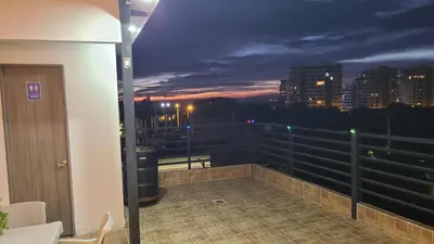 a balcony with a view of a city at night at Hospedaje Mi Fortaleza, Con Piscina, Parqueadero y estamos a 10 Minutos Caminando a Playa Dormida in Santa Marta