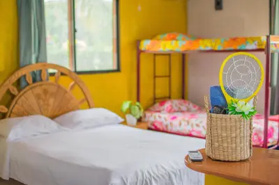 a bedroom with a bed and a table and bunk beds at Cabañas Los Venaos in San Bernardo del Viento