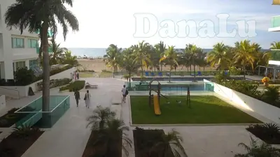 a view of a park with palm trees and the ocean at Hermoso apartamento en la playa in Cartagena de Indias