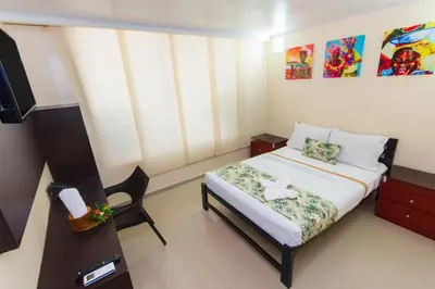a small room with a bed and a chair in it at Hotel Marina Suites By GEH Suites in Cartagena de Indias