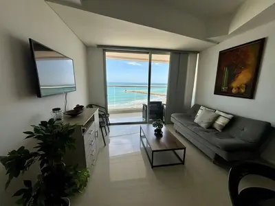 a living room with a couch and a view of the ocean at Playa Cartagena Apartments in Cartagena de Indias