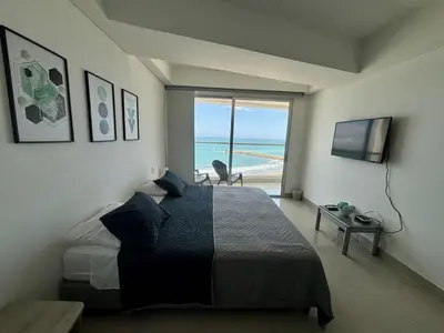 a bedroom with a bed and a view of the ocean at Playa Cartagena Apartments in Cartagena de Indias
