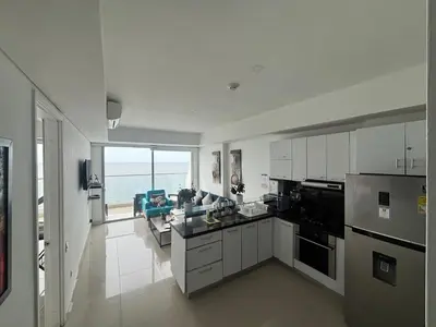 a kitchen with white cabinets and a view of the ocean at Playa Cartagena Apartments in Cartagena de Indias