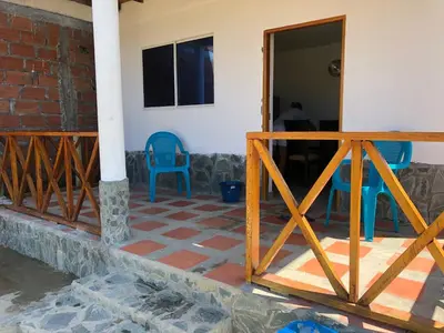 a patio with two blue chairs and a building at Cabaña La Blanquita in San Bernardo del Viento