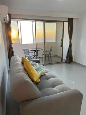 a couch with a yellow pillow in a living room at Hermoso Apartamento, con vista al mar, en Cartagena de Indias, dos cuartos in Cartagena de Indias
