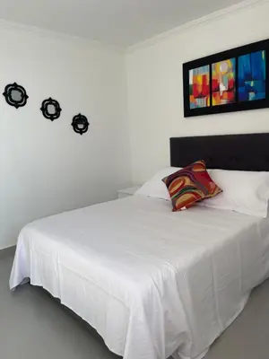 a bedroom with a white bed with a white bedspread at Hermoso Apartamento, con vista al mar, en Cartagena de Indias, dos cuartos in Cartagena de Indias