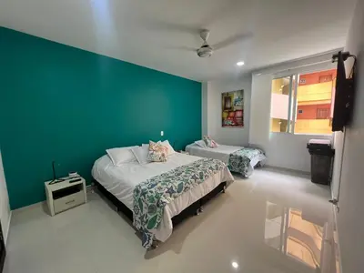 a bedroom with two beds and a green wall at Hermoso apartamento en la mejor zona de la ciudad in Cartagena de Indias