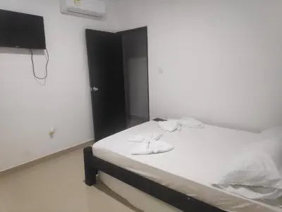 a bedroom with a bed with towels on it at Apartamentos Villa Leonor in Coveñas