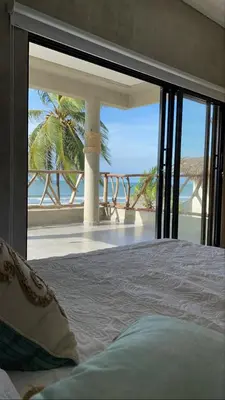 a bedroom with a bed with a view of the beach at Sea La Vie in San Bernardo del Viento