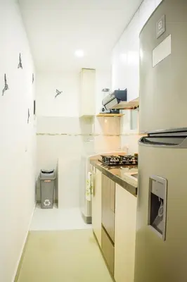a white kitchen with a refrigerator and a sink at Luxury apartamento ubicación central y piscina. in Cartagena de Indias