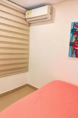 a bedroom with a bed and a air conditioner on the wall at Luxury apartamento ubicación central y piscina. in Cartagena de Indias