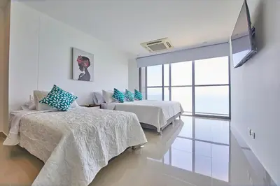 a white room with two beds and a window at Beachfront Paradise with Outstanding Sunset Views in Cartagena de Indias