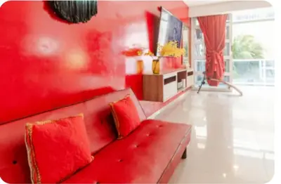 a red couch in a living room with red walls at Casa con Piscina Privada Playas del Mar in Cartagena de Indias