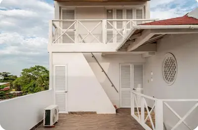 a white house with a balcony with a porch at Casa con Piscina Privada Playas del Mar in Cartagena de Indias