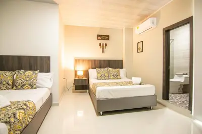 a hotel room with two beds and a bathroom at Cienaguas Hotel in Ciénaga