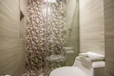 a bathroom with a toilet and a glass shower at Cienaguas Hotel in Ciénaga