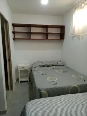 a bedroom with two beds and a shelf above them at Casa Playa Arreboles in Cartagena de Indias