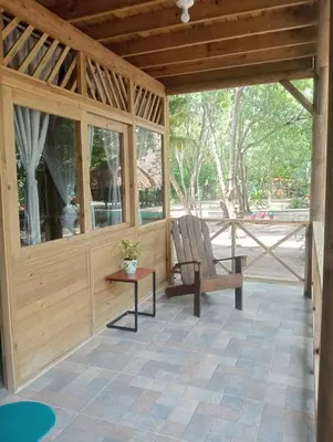 a wooden pavilion with a chair and a table at Centro Ubuntu in Isla Grande
