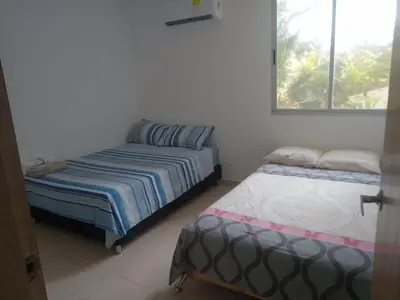 a bedroom with two beds and a window at Cabaña Apartamento En Coveñas - Fontaine Bleu in Coveñas