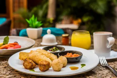 a table with a plate of food and a cup of coffee at Ananda Hotel Boutique in Cartagena de Indias
