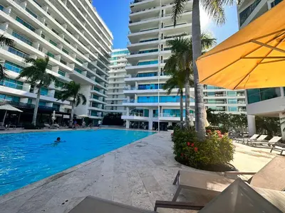 a swimming pool in front of a large building at Apto- Condominio H Sonesta - Morros-salida a la playa - cerca Hotel Americas in Cartagena de Indias