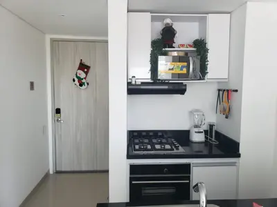 a kitchen with a stove top oven next to a door at Apto- Condominio H Sonesta - Morros-salida a la playa - cerca Hotel Americas in Cartagena de Indias