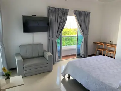 a bedroom with a bed and a chair and a window at Hermoso y amplio apartamento en Cartagena de Indias in Cartagena de Indias