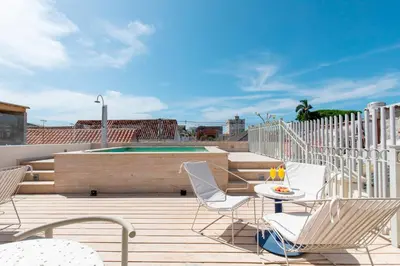 a patio with chairs and a table and a pool at B Haus Hotel Boutique in Cartagena de Indias