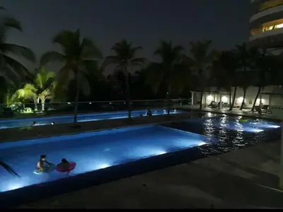 a swimming pool at night with people in the water at Cartagena Genius Morros frente al mar in Cartagena de Indias