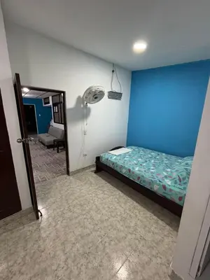 a bedroom with a bed and a blue wall at Apartamentos San Felipe in Cartagena de Indias