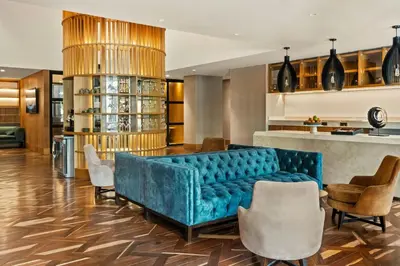 a living room with a blue couch and chairs at Barranquilla Marriott Hotel in Barranquilla