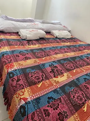 a bed with a colorful blanket on top of it at En mi casa cartagena in Cartagena de Indias