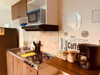 a kitchen with a stove top and a microwave at Apartamento Exclusivo - Caribe Campestre Coveñas in Coveñas
