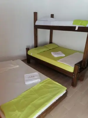 two bunk beds in a room with green sheets at ZABDI COVEÑAS in Coveñas