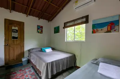 two beds in a room with a door and a window at Hostal Campomar in Santa Veronica