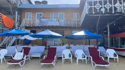 a group of tables and chairs with blue umbrellas at Hostal azul beach isla baru in Playa Blanca