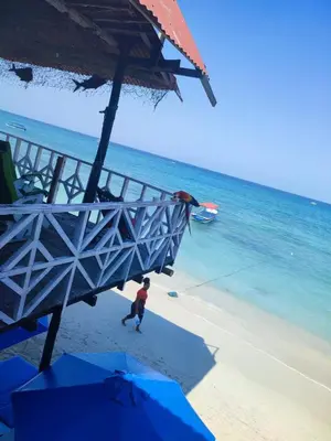 a person walking on the beach near the ocean at Hostal azul beach isla baru in Playa Blanca