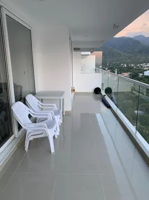 a white balcony with white chairs and a table at Edificio kuali apto 1704 in Santa Marta