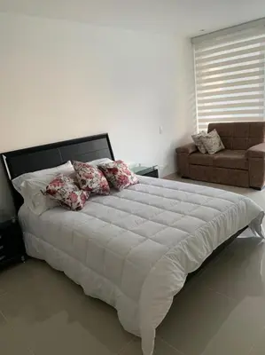 a large white bed in a bedroom with a couch at Edificio kuali apto 1704 in Santa Marta