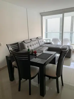 a dining room with a table and chairs and a couch at Edificio kuali apto 1704 in Santa Marta