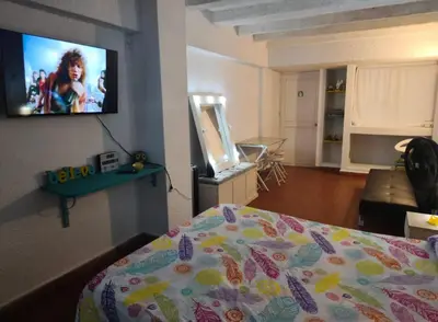 a bedroom with a bed and a flat screen tv on the wall at @casa__grace in Cartagena de Indias
